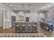 Open-concept kitchen with white cabinets, stainless steel appliances, a center island with bar stools, and hardwood floors at 116 Palermo Ct, Apex, NC 27539