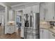 Kitchen features white cabinets and stainless steel refrigerator, with an open view to the dining room at 116 Palermo Ct, Apex, NC 27539