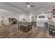 Modern kitchenette featuring white cabinets, stainless steel appliances, bar seating, and stylish wood-look flooring at 116 Palermo Ct, Apex, NC 27539