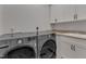 This laundry room features a modern washer and dryer, complemented by ample white cabinetry and a built-in sink at 116 Palermo Ct, Apex, NC 27539