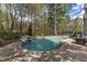 Beautiful pool with a rock waterfall feature surrounded by a brick patio and lush greenery at 116 Palermo Ct, Apex, NC 27539