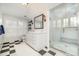 Bright bathroom featuring a glass enclosed shower with a built in bench, checkered flooring, and white cabinetry at 119 Faison Rd, Chapel Hill, NC 27517