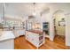 Bright kitchen with white cabinets, stainless steel appliances, a center island, and hardwood floors, ideal for cooking at 119 Faison Rd, Chapel Hill, NC 27517