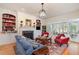 Cozy living room with a fireplace, custom built-ins, and French doors leading to a sunroom, ideal for entertaining at 119 Faison Rd, Chapel Hill, NC 27517