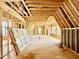 Attic under construction features exposed wood framing and multiple windows for ample natural light at 1218 Kingwood Dr, Raleigh, NC 27609
