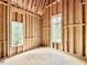 Bedroom's wood framework highlights window placement and ceiling height, during the construction phase at 1218 Kingwood Dr, Raleigh, NC 27609