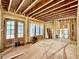 An unfinished room with exposed wood framework, large glass doors and windows offering ample natural light at 1218 Kingwood Dr, Raleigh, NC 27609