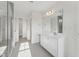 Bright main bathroom featuring double sinks, tiled floors, and a glass-enclosed shower at 1427 Goldsboro Ave, Sanford, NC 27330