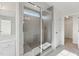 Modern tiled shower with glass enclosure and a view towards the walk-in closet and vanity at 1427 Goldsboro Ave, Sanford, NC 27330