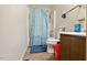 Simple bathroom with blue shower curtain, basic toilet, and vanity with open storage at 1431 Cherrycrest Dr, Durham, NC 27704