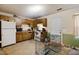 Kitchen with wooden cabinetry, white appliances, and dining area at 1431 Cherrycrest Dr, Durham, NC 27704