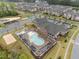Aerial view of a community pool area with lounge chairs, umbrellas, and surrounding buildings at 1726 Wimberly Rd, Apex, NC 27523
