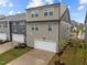 Rear view of modern townhome featuring an attached garage and neutral siding at 1726 Wimberly Rd, Apex, NC 27523