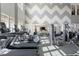 Modern fitness center featuring treadmills, ellipticals, and weight machines with a chevron accent wall at 1726 Wimberly Rd, Apex, NC 27523