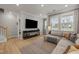 Bright living room with hardwood floors, a large sectional sofa, and a mounted TV at 1726 Wimberly Rd, Apex, NC 27523