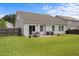 Well-maintained backyard with a patio, table, chairs, and green grass, perfect for outdoor living and entertaining at 1728 Fern Hollow Trl, Wake Forest, NC 27587