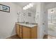 Bathroom featuring double sinks, granite countertops, and a tiled floor, seamlessly connecting to an adjacent bedroom at 1728 Fern Hollow Trl, Wake Forest, NC 27587