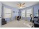 Sunlit bedroom with a ceiling fan, multiple windows, and a comfortable workspace for productivity at 1728 Fern Hollow Trl, Wake Forest, NC 27587