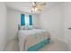 A cozy bedroom with a ceiling fan and a large window with blue curtains at 1728 Fern Hollow Trl, Wake Forest, NC 27587