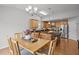 Bright dining room with hardwood floors, chandelier, and seating for six near an open kitchen at 1728 Fern Hollow Trl, Wake Forest, NC 27587
