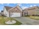 Attractive one-story home with brick accents, an attached garage, and professionally landscaped grounds at 1728 Fern Hollow Trl, Wake Forest, NC 27587