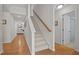 Hallway featuring hardwood floors and a staircase, seamlessly connecting different living spaces at 1728 Fern Hollow Trl, Wake Forest, NC 27587