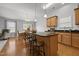 Modern kitchen featuring wood cabinets, granite countertops, stainless steel appliances, and an island with bar seating at 1728 Fern Hollow Trl, Wake Forest, NC 27587