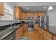 Modern kitchen with stainless steel appliances, granite countertops, light wood cabinets, and tile backsplash at 1728 Fern Hollow Trl, Wake Forest, NC 27587