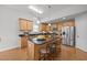 Modern kitchen featuring wood cabinets, granite countertops, stainless steel appliances, and an island with bar seating at 1728 Fern Hollow Trl, Wake Forest, NC 27587