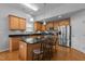 Open kitchen with stainless steel appliances, breakfast bar, hardwood floors, and light wood cabinets at 1728 Fern Hollow Trl, Wake Forest, NC 27587