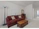 Inviting living room with a cozy maroon couch, wooden trunk, and natural light at 1728 Fern Hollow Trl, Wake Forest, NC 27587