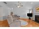 Living room with vaulted ceilings, hardwood floors, sectional couch, fireplace, and large screen TV at 1728 Fern Hollow Trl, Wake Forest, NC 27587