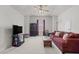 Spacious living room with neutral carpet, featuring a comfortable sofa and a television for relaxation at 1728 Fern Hollow Trl, Wake Forest, NC 27587