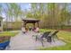 Outdoor gazebo featuring seating and a grill, adjacent to a patio with lounge chairs at 190 Alcock Ln, Youngsville, NC 27596