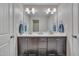Bathroom with a double vanity with dark wood cabinets, a large mirror, and great lighting at 190 Alcock Ln, Youngsville, NC 27596
