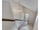 The staircase is brightly lit with a decorative hanging light fixture and a view of the front door at 190 Alcock Ln, Youngsville, NC 27596