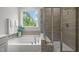 Bathroom featuring a soaking tub and a shower with decorative tilework at 1915 Kings Knot Ct, Apex, NC 27502
