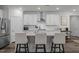 Modern kitchen with white cabinetry, stainless steel appliances, and an island with bar stool seating at 1915 Kings Knot Ct, Apex, NC 27502