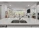 Bright kitchen island with stainless steel sink and faucet overlooking the open living room with fireplace at 1915 Kings Knot Ct, Apex, NC 27502
