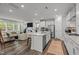 Modern kitchen island, living room with a fireplace and stainless steel appliances in an open concept floor plan at 1915 Kings Knot Ct, Apex, NC 27502