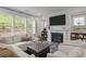 Comfortable living room with large windows, modern fireplace, and plush seating for relaxation at 1915 Kings Knot Ct, Apex, NC 27502