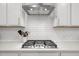 Modern stove top with white backsplash at 1915 Kings Knot Ct, Apex, NC 27502