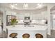 Well-lit kitchen with white cabinetry, stainless steel appliances, a quartz island and pendant lights at 2112 Bradford Mill Ct, Apex, NC 27539