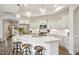Bright kitchen with white cabinets, quartz countertops, large island and stainless appliances at 2112 Bradford Mill Ct, Apex, NC 27539