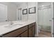 Bright bathroom featuring a double sink vanity, framed art and a shower with a decorative curtain at 2157 Blue Iris Way, Zebulon, NC 27597