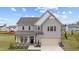 Charming two-story home featuring a manicured lawn, attached two-car garage, and a welcoming front porch at 2157 Blue Iris Way, Zebulon, NC 27597