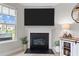 Close-up of the living room fireplace, decor, and bright windows at 2157 Blue Iris Way, Zebulon, NC 27597