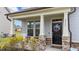 Inviting front porch with rocking chairs, stone accents, and a charming front door with seasonal wreath at 2157 Blue Iris Way, Zebulon, NC 27597