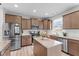 Modern kitchen with stainless steel appliances, granite countertops, a center island, and stylish wood cabinetry at 2157 Blue Iris Way, Zebulon, NC 27597