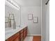 Bathroom features dual sinks, wood cabinets, framed mirrors, and warm lighting at 228 Dove Cottage Ln, Cary, NC 27519